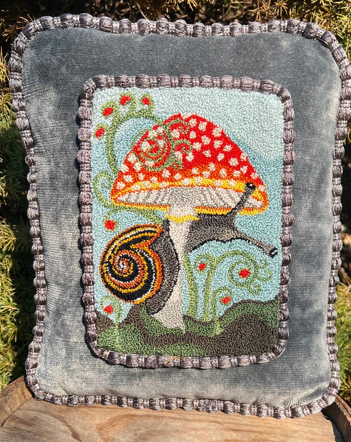  The Pattern Entwined is a punch Needle Embroidery pattern that used thread and a punch needle to create the design. Entwinted design depicts a snail wrapping itself around a colorful mushroom. Copyright © 2024 Kelly Kanyok of Orphaned Wool.