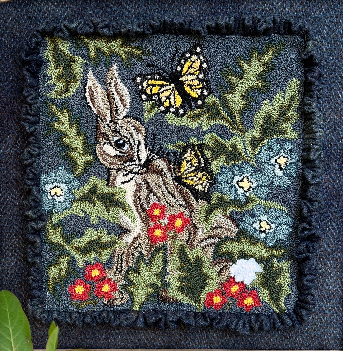 Hare with Friend Punch Needle Pattern by Orphaned Wool. This lovely bunny and butterflies design was created using DMC Floss. This little rabbit is nestled in with flowers and foliage and sweet butterflies.