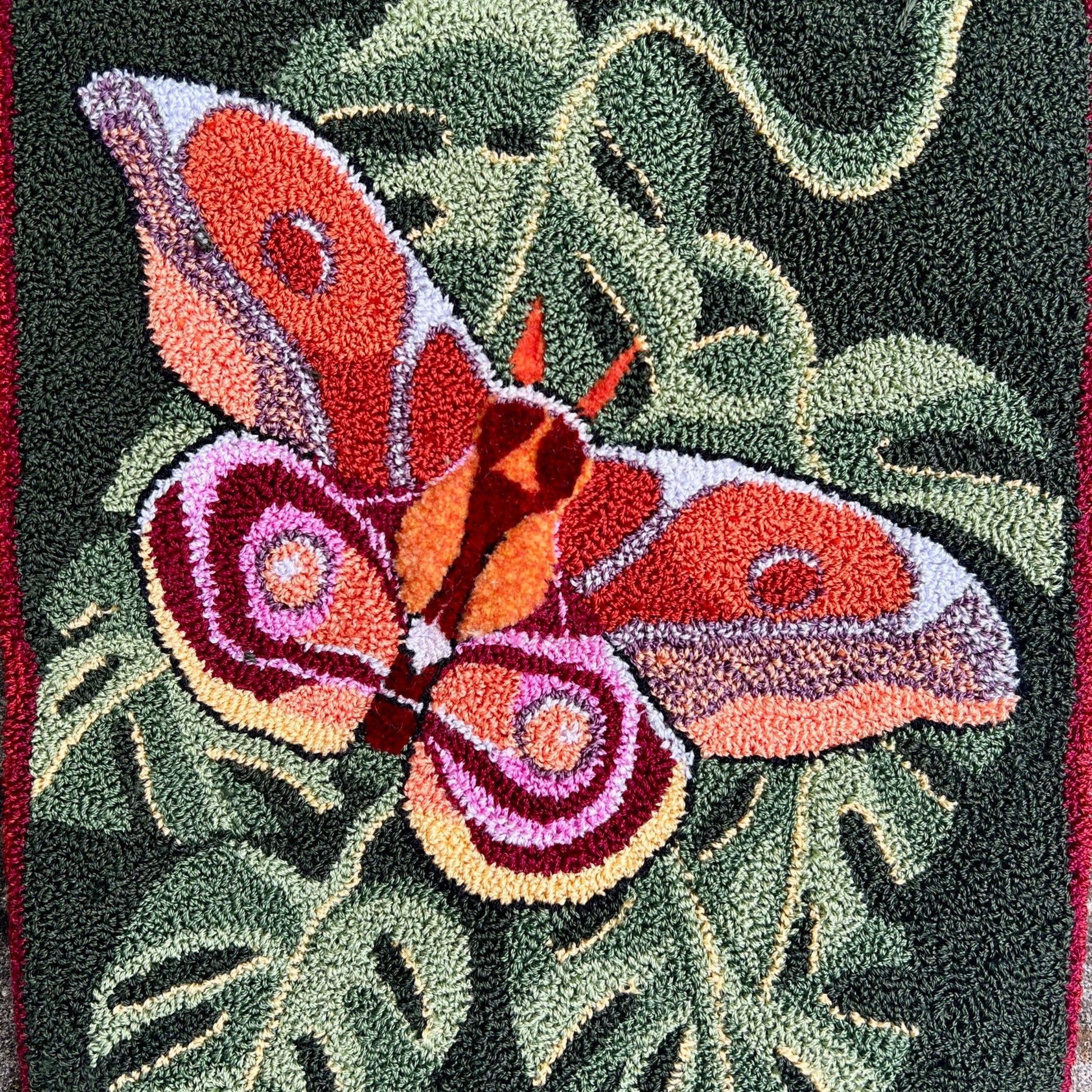 Bullseye Moth Paper Rug Hooking Pattern by Orphaned Wool, copyright © 2023 Kelly Kanyok. This pattern design is of a beautiful Bullseye Moth on top of a collection of leaves. Enjoy the stunning color inspired by nature herself.  