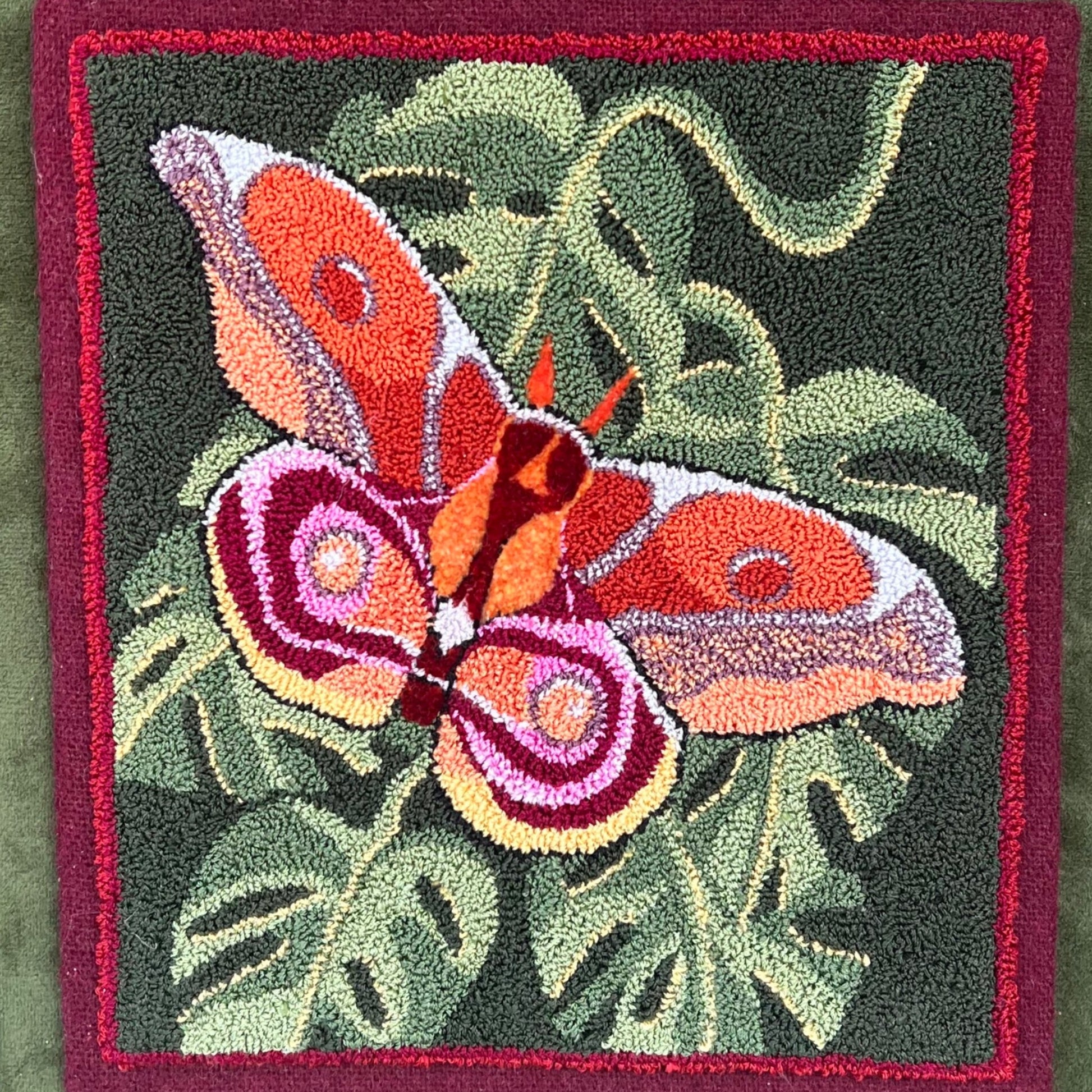 Bullseye Moth Paper Rug Hooking Pattern by Orphaned Wool, copyright © 2023 Kelly Kanyok. This pattern design is of a beautiful Bullseye Moth on top of a collection of leaves. Enjoy the stunning color inspired by nature herself.
