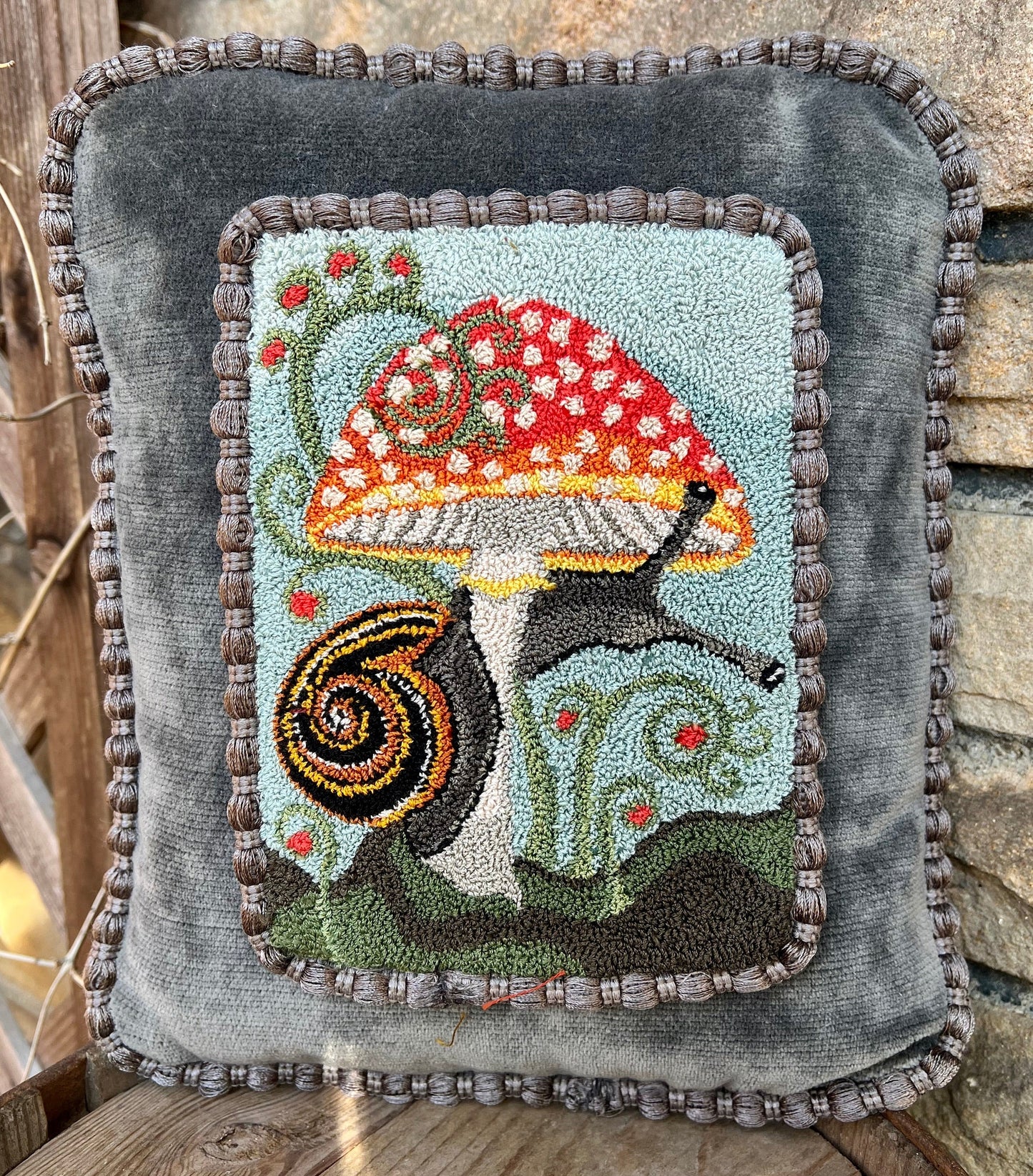 The Pattern Entwined is an PDF digial downloadable punch Needle Embroidery pattern that used thread and a punch needle to create the design. Entwined design depicts a snail wrapping itself around a colorful mushroom. Copyright © 2024 Kelly Kanyok of Orphaned Wool.