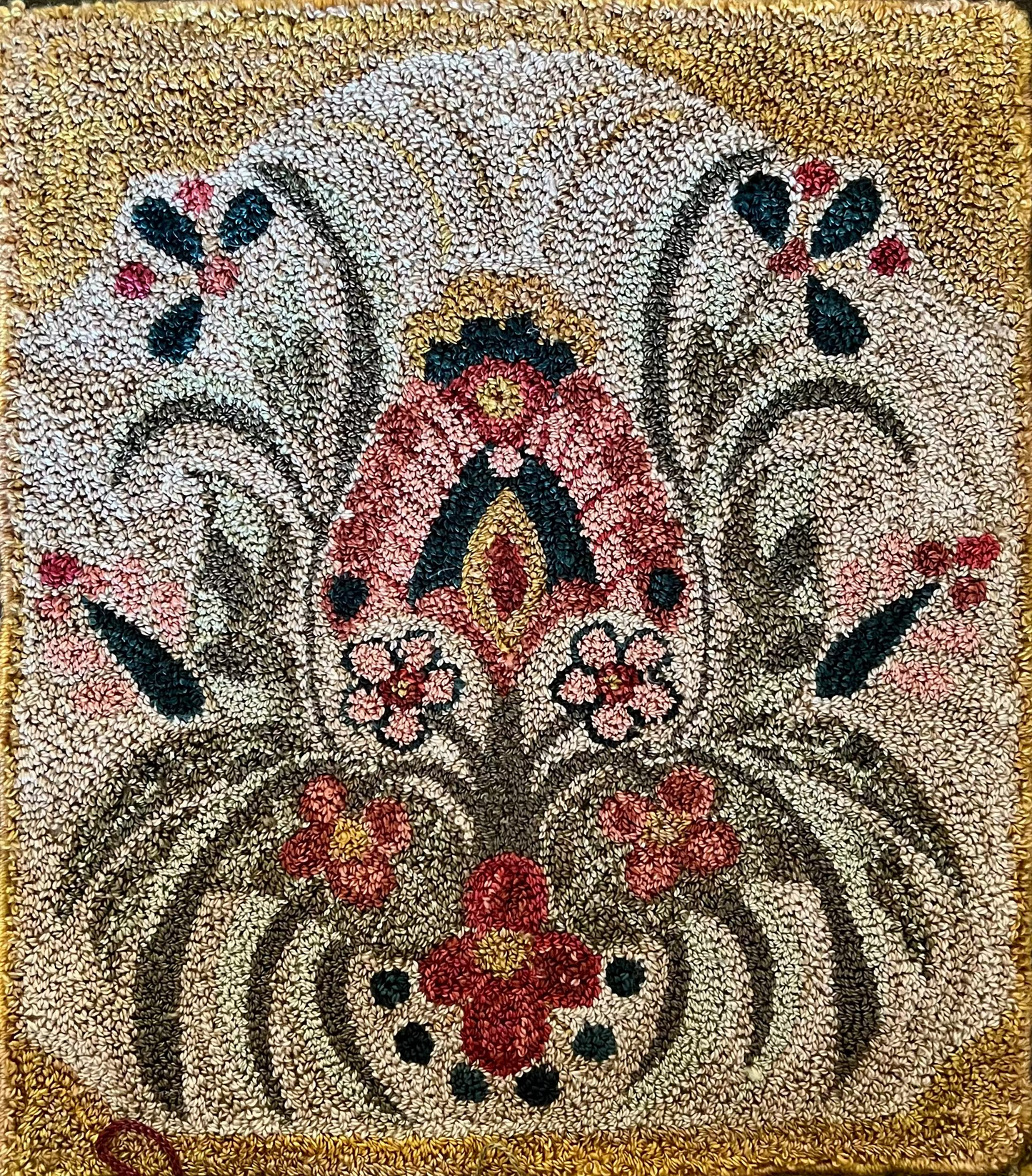 Decorative rug with floral and rooster design on a wooden surface