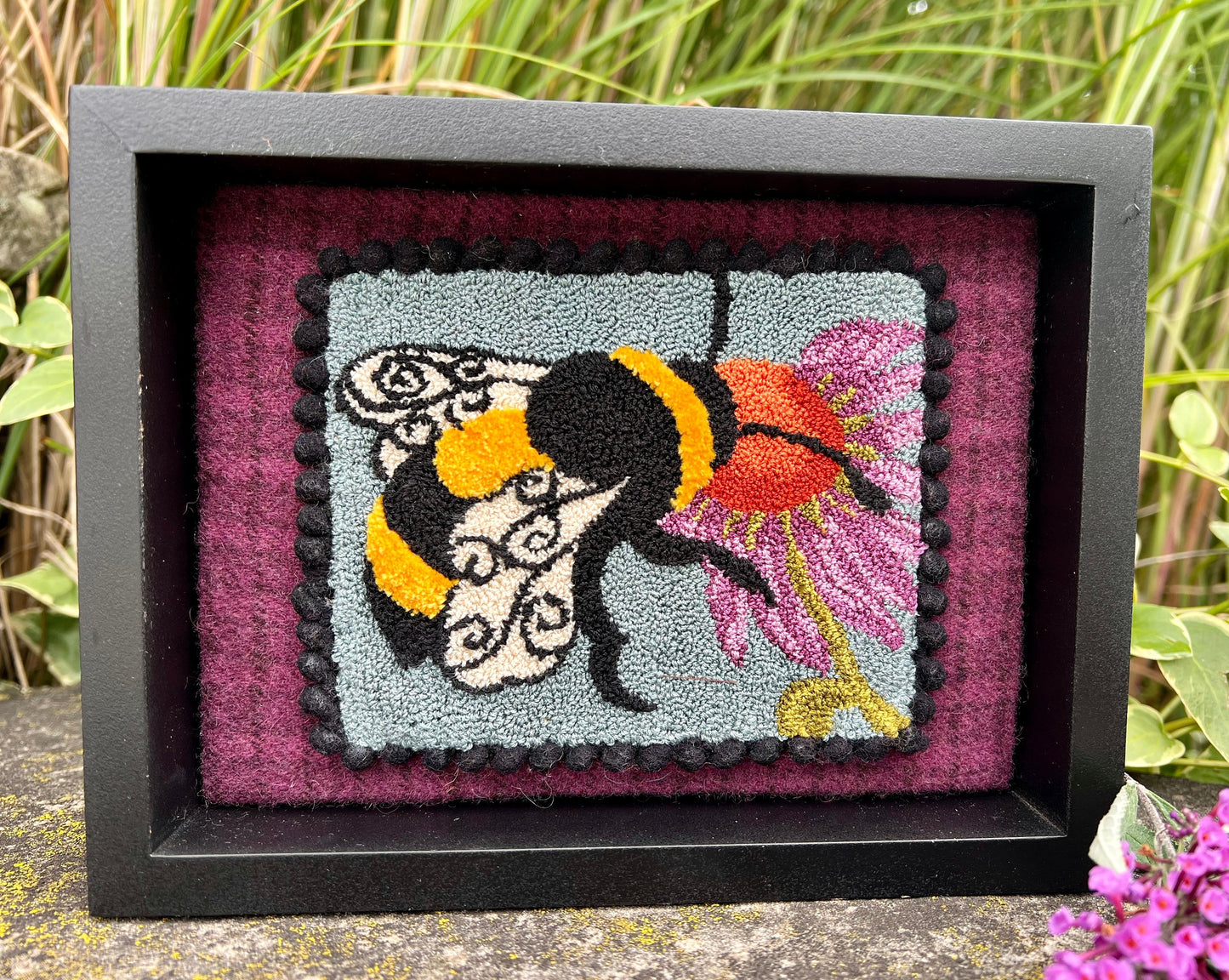 A Bee's Kiss- Needle Punch Pattern by Orphaned Wool, Copyright © 2023 Kelly Kanyok. This pattern is available as a Printed on Cloth pattern or Paper Pattern. The design of a bee kissing a colorful flower.