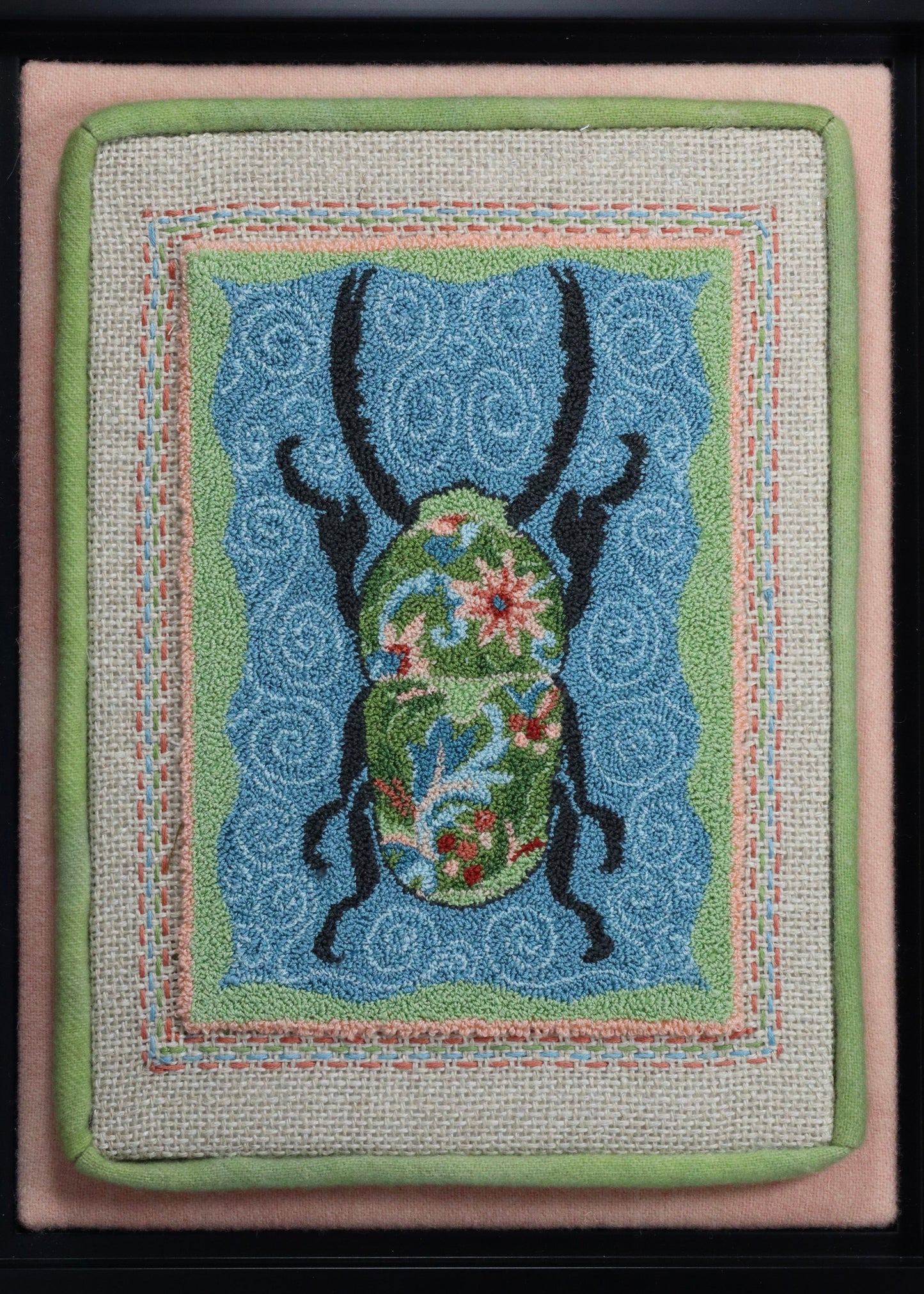 Punch Needle Embroidery artwork of a beetle with a floral design on a blue background, framed in black.