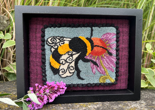 A Bee's Kiss- Needle Punch Pattern by Orphaned Wool, Copyright © 2023 Kelly Kanyok. This pattern is available as a Printed on Cloth pattern or Paper Pattern. The design of a bee kissing a colorful flower.