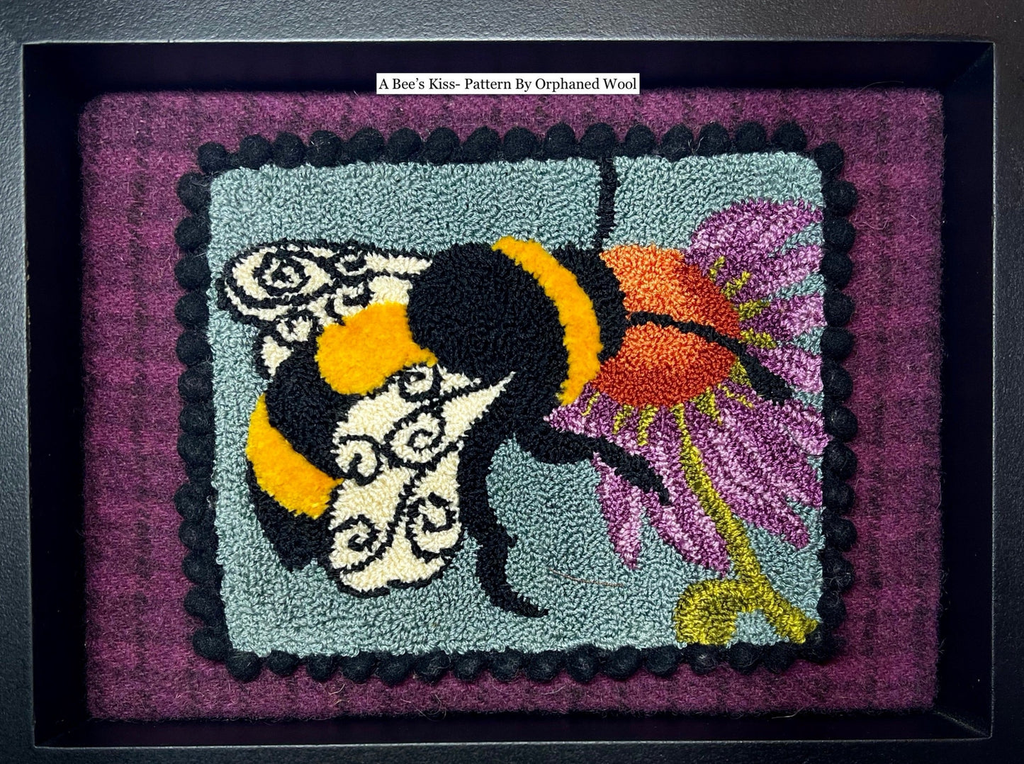 A Bee's Kiss- Needle Punch Pattern by Orphaned Wool, Copyright © 2023 Kelly Kanyok. This pattern is available as a Printed on Cloth pattern or Paper Pattern. The design of a bee kissing a colorful flower.
