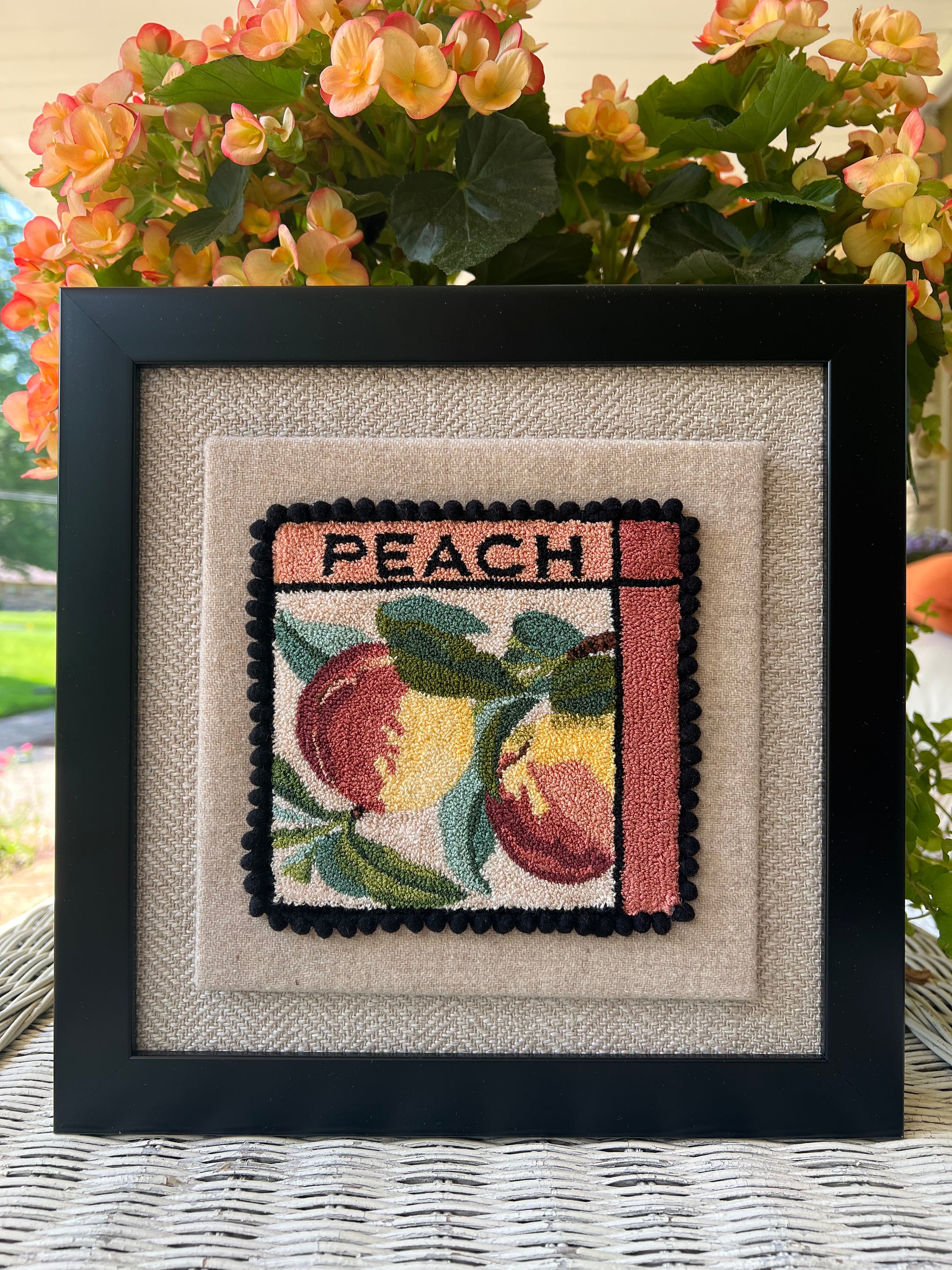 Peach- Punch Needle Pattern by Orphaned Wool, Copyright ©2025 Kelly Kanyok. Available in paper, cloth, printed patterns, or a set of four patterned designs (Fruit Series). Pattern features  two colorful peaches with the word PEACH at the top of the design.