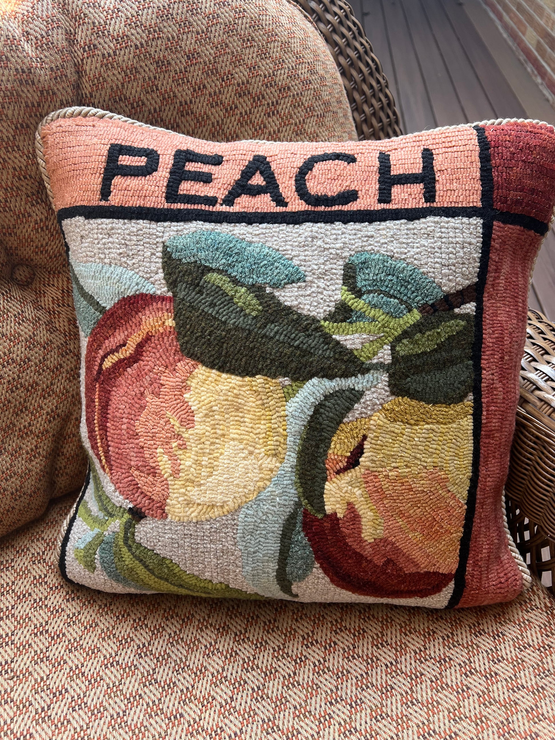 Peach paper rug hooking pattern by Orphaned Wool, copyright © 2025 Kelly Kanyok. This paper pattern is designed to be enlarged. This picture shows the finished design enlarged 300% to create a beautiful pillow. The design features two peaches with the word peach on the top. This pattern is one of four fruit patterns available. Sold individually or as a set of four. Lemon, Lime, Peach, and Cherry designs.