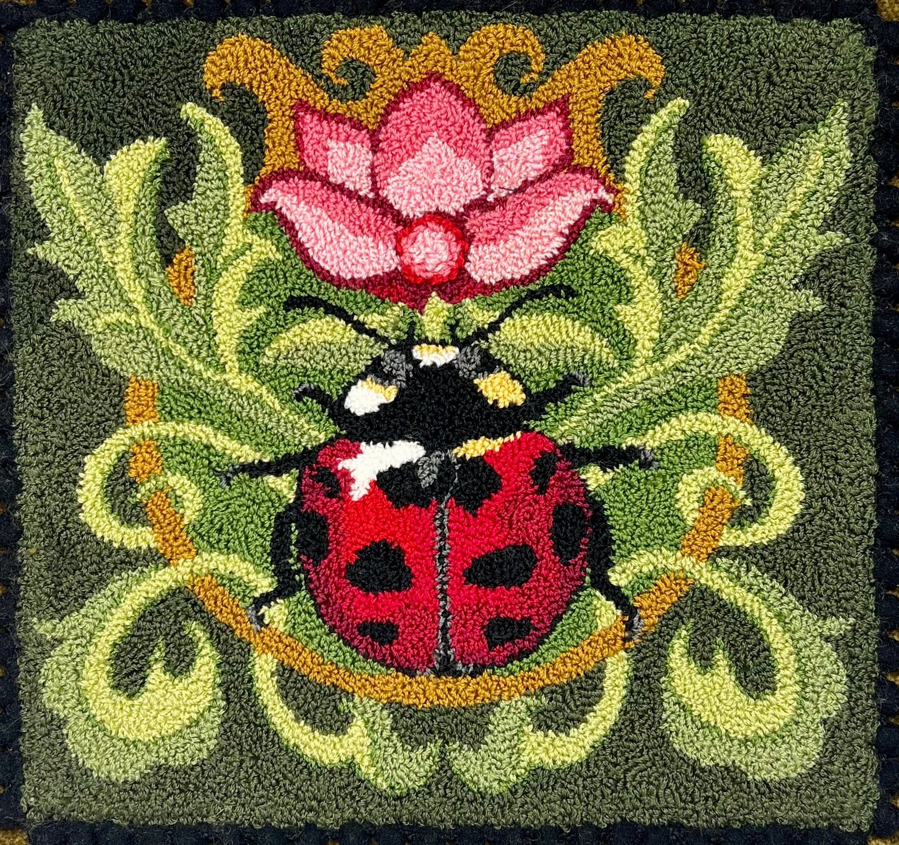 Ladybug pattern by Orphaned Wool, A colorful garden ladybug on leaves with a pink flower.