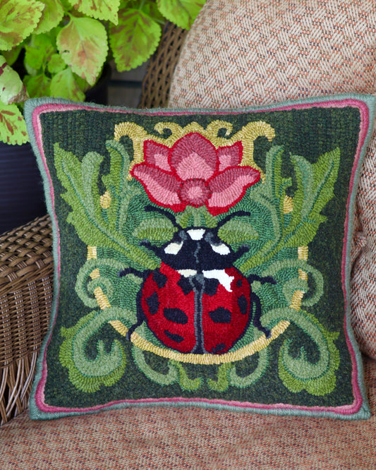 Decorative pillow featuring a ladybug with a flower Rug Hooking Pattern - By Orphaned Wool