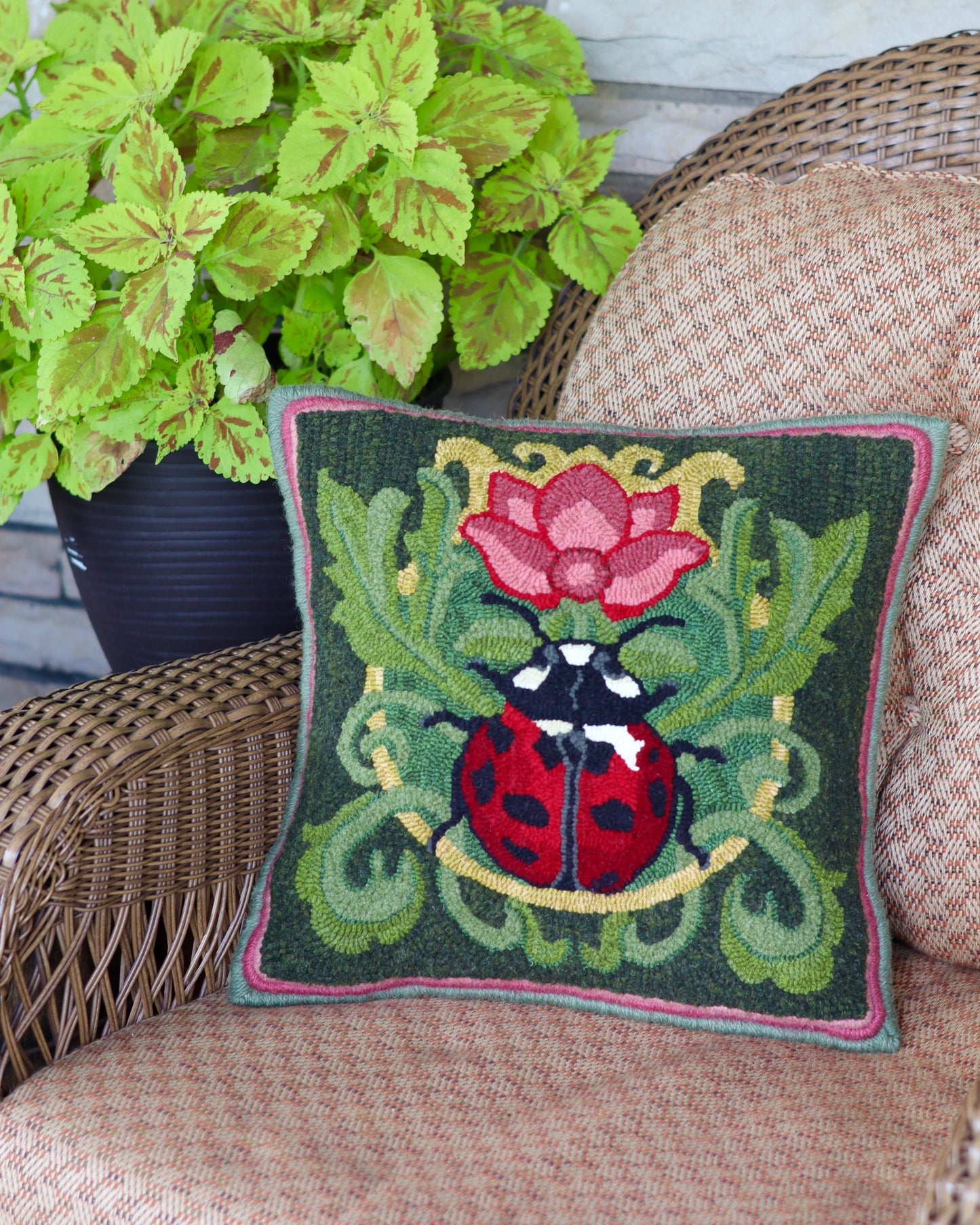 Decorative pillow featuring a ladybug with a flower Rug Hooking Pattern - By Orphaned Wool