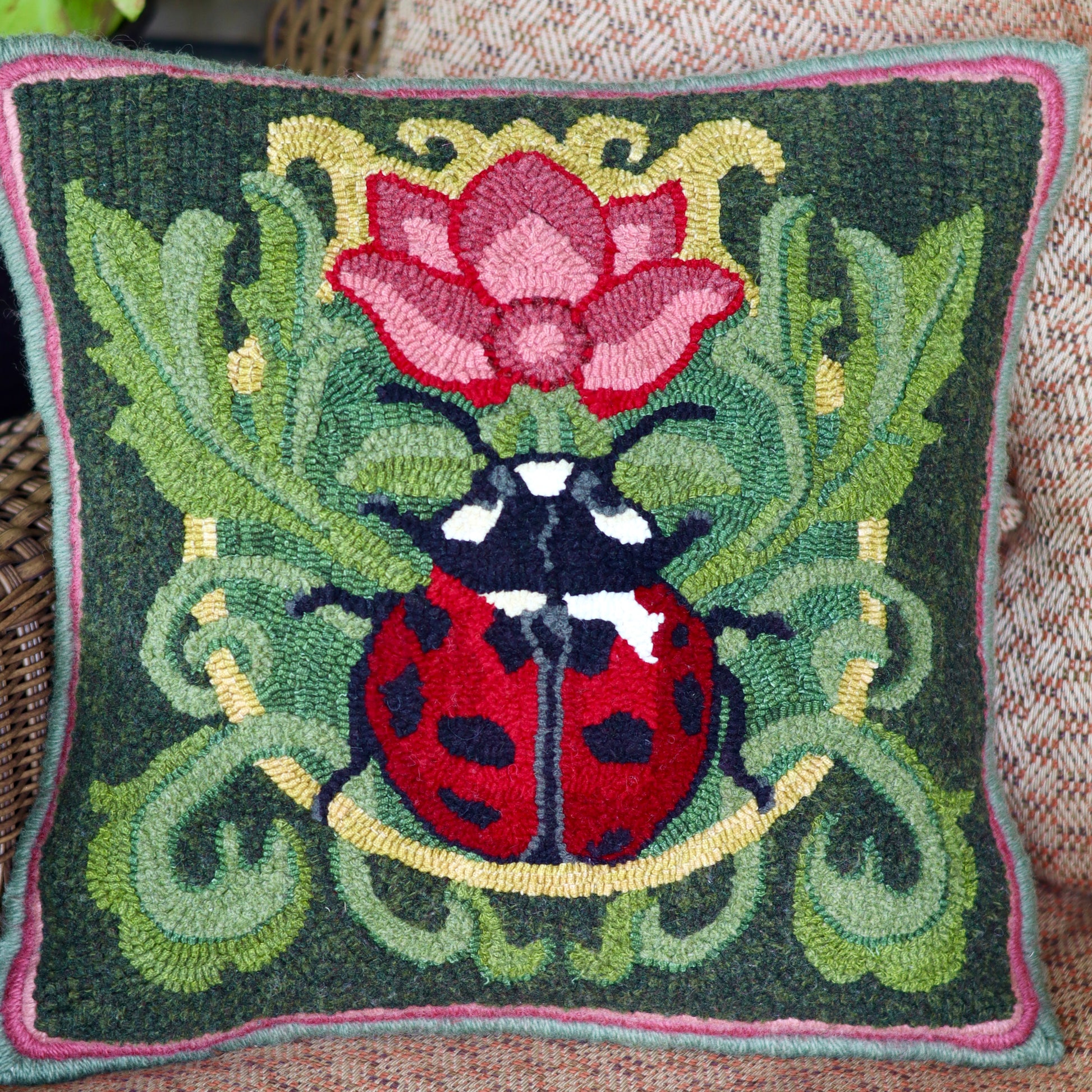 Decorative pillow featuring a ladybug with a flower Rug Hooking Pattern - By Orphaned Wool